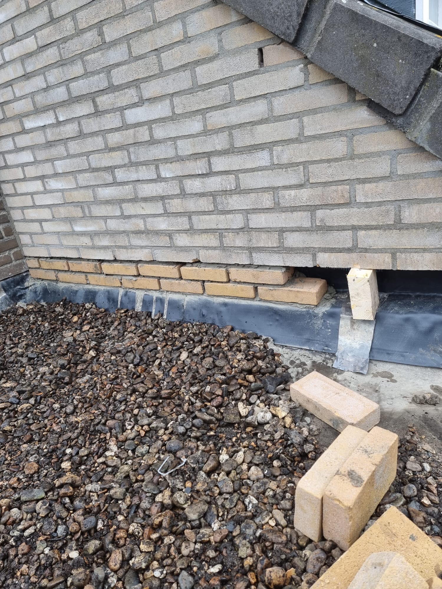 Constructief gevelherstel aan onderzijde van lichte bakstenen muur met open metselwerk(1) Constructief gevelherstel aan lichte bakstenen muur met open metselwerk
