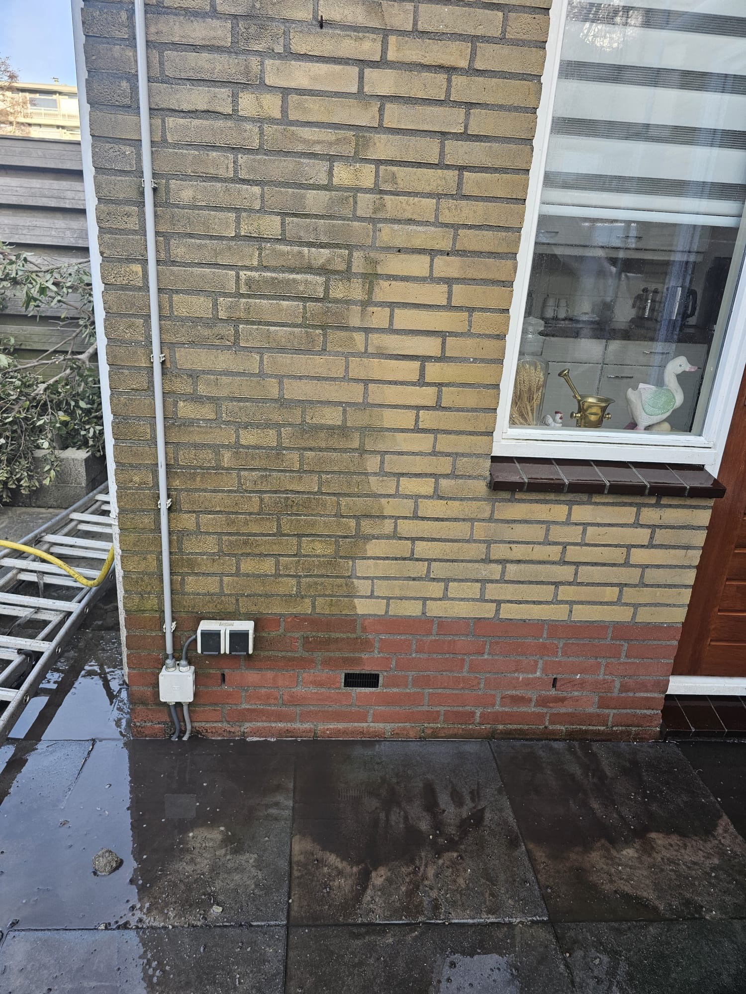Lichte bakstenen gevel waarvan het verschil duidelijk zichtbaar is van wat is schoongemaaktJPG Zichtbaar verschil tussen gereinigde en vervuilde bakstenen gevel