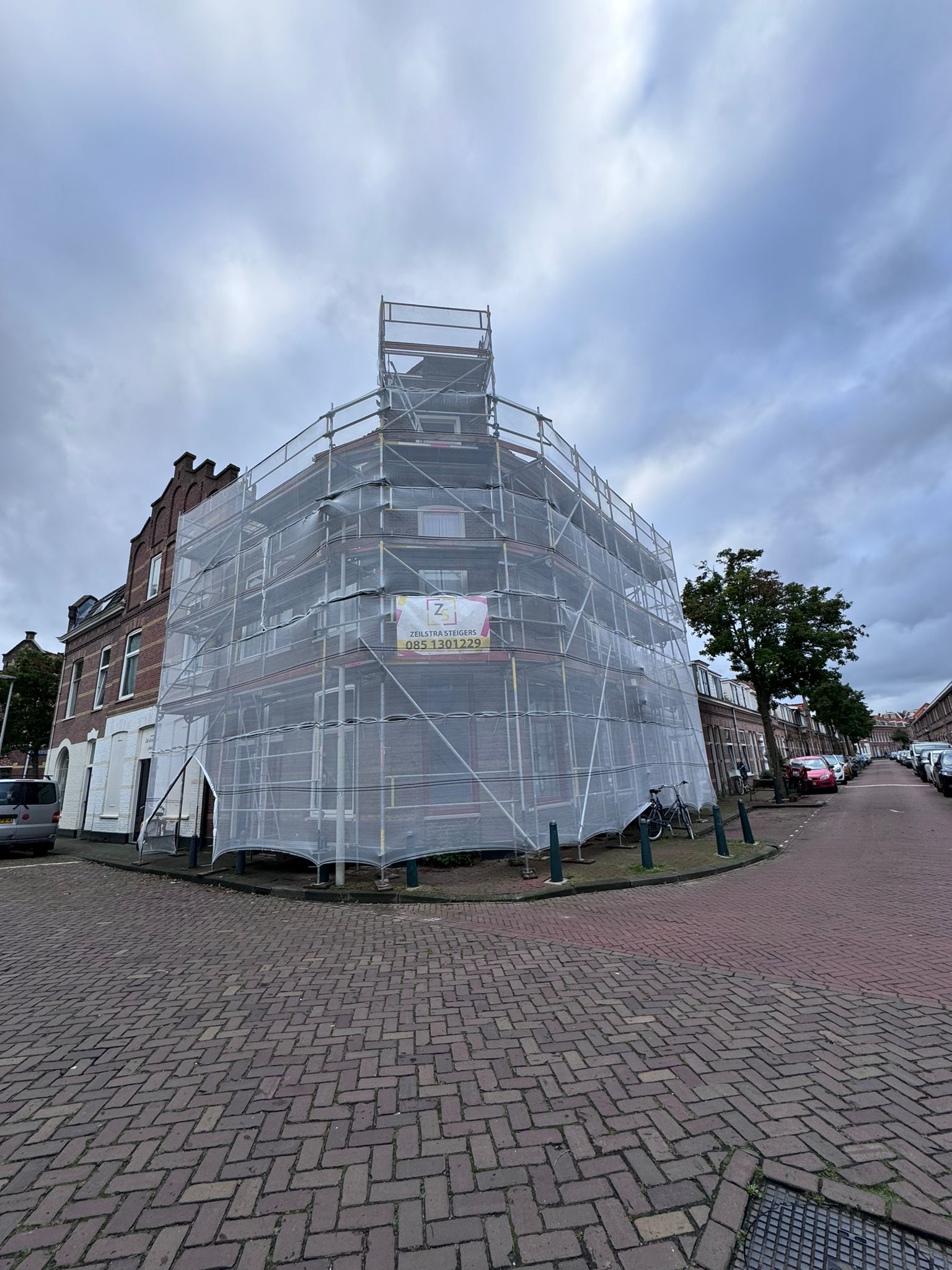 Woning volledig in de steigers met steigerdoek voor grootschalige gevelrenovatie Woning volledig in de steigers voor grootschalige gevelrenovatie en gevelverankering